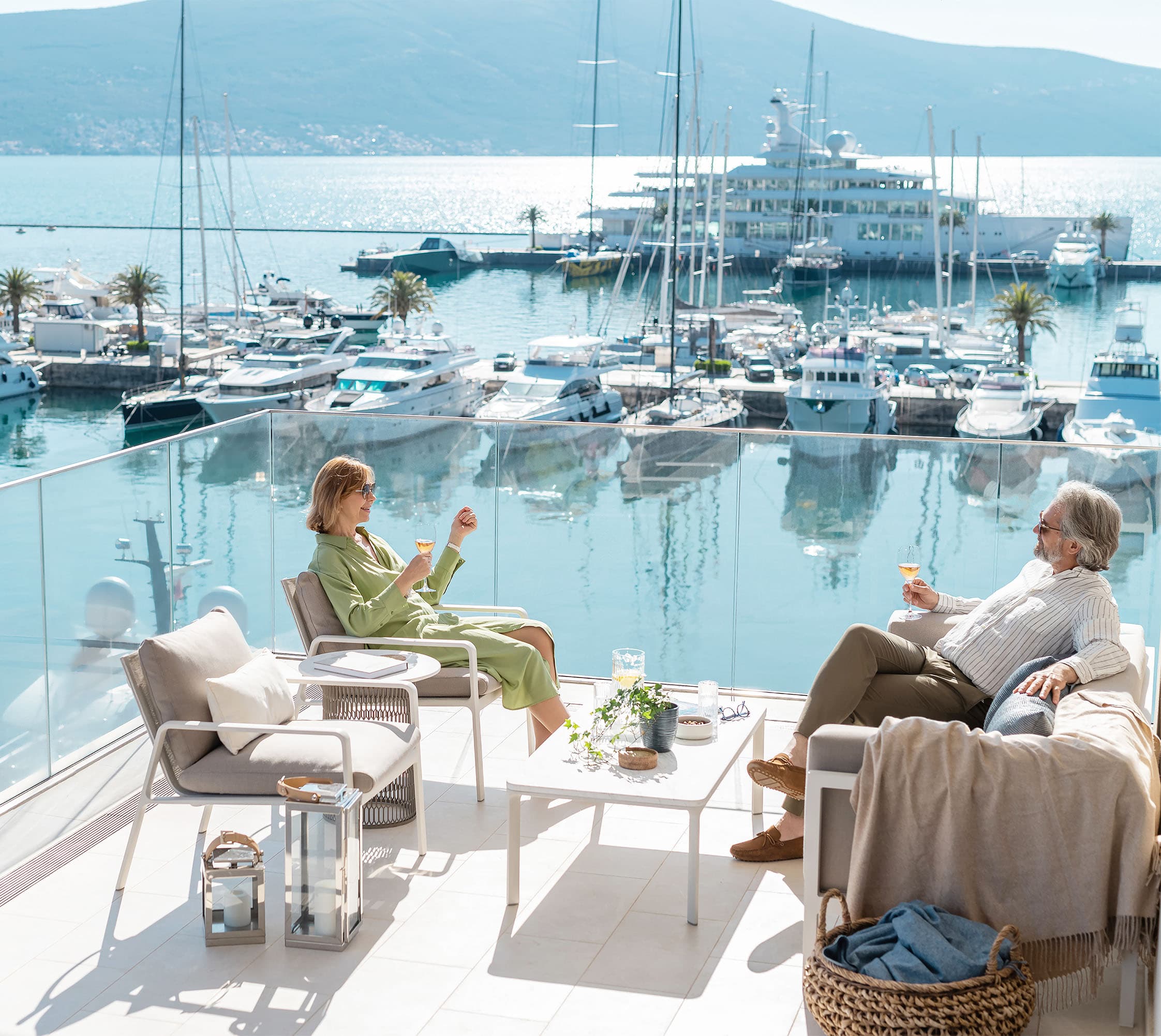 Couple sitting on balcony overlooking marina Montenegro