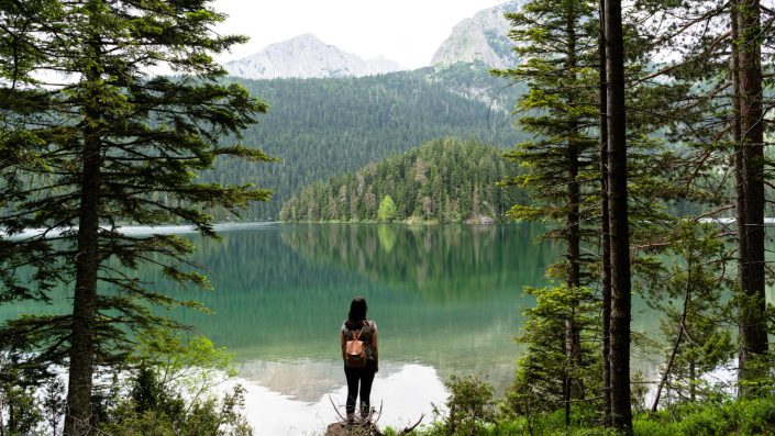 A woman looking into a lake.