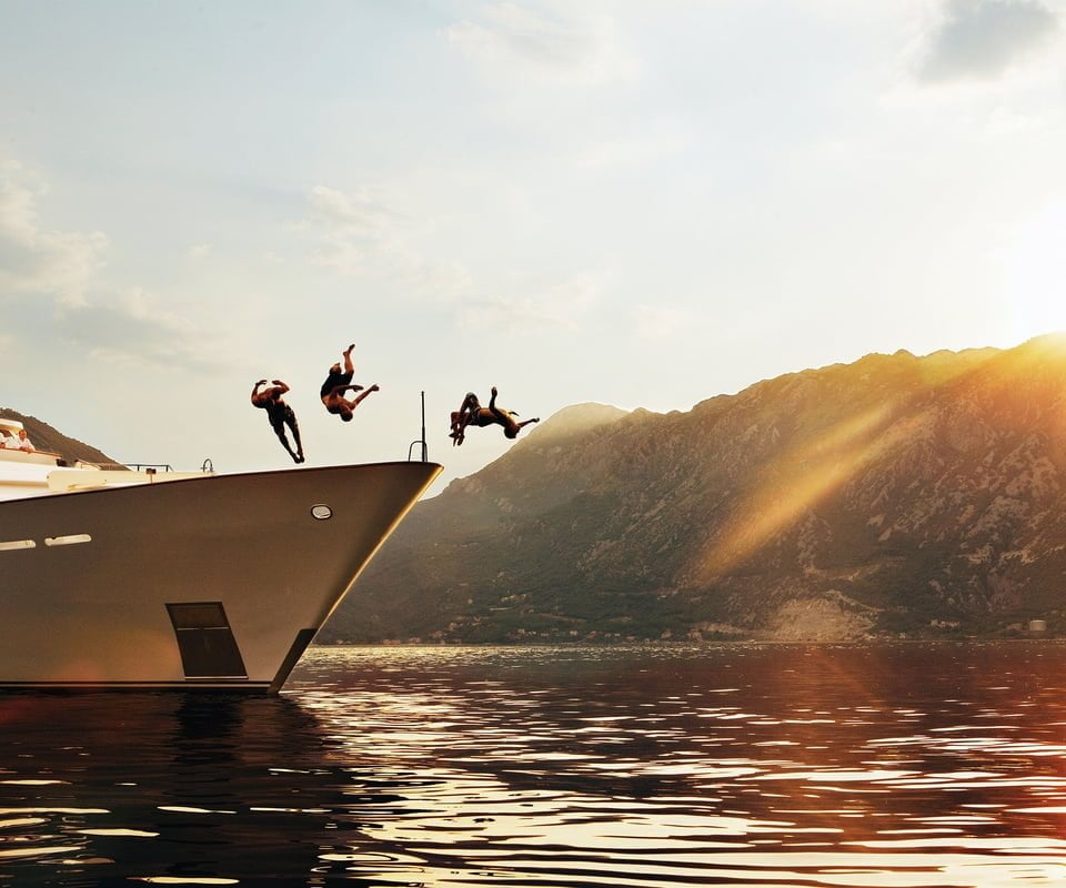 People diving off yacht into water