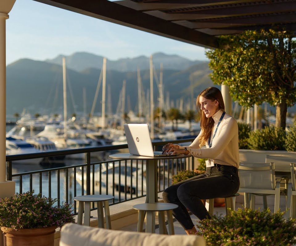 Woman working on laptop in front of the marina