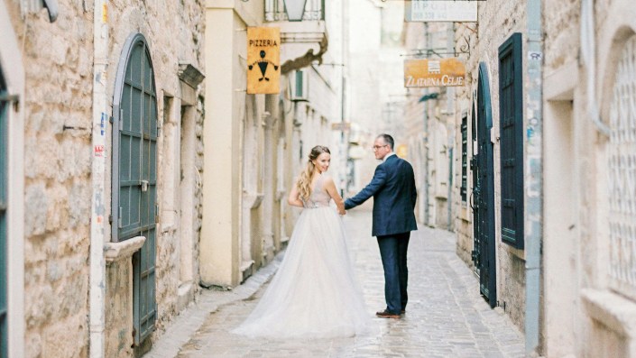 A couple getting married and standing in the alley.