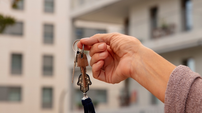 Close-up of a hand holding a set of keys outdoors.
