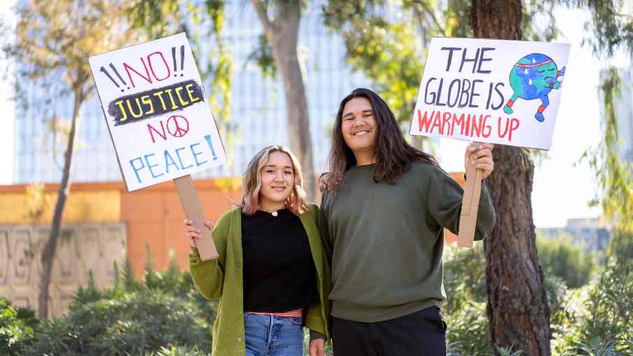 Young people at a World Environment Day rally carrying placards calling for environmental awareness and sustainable change.