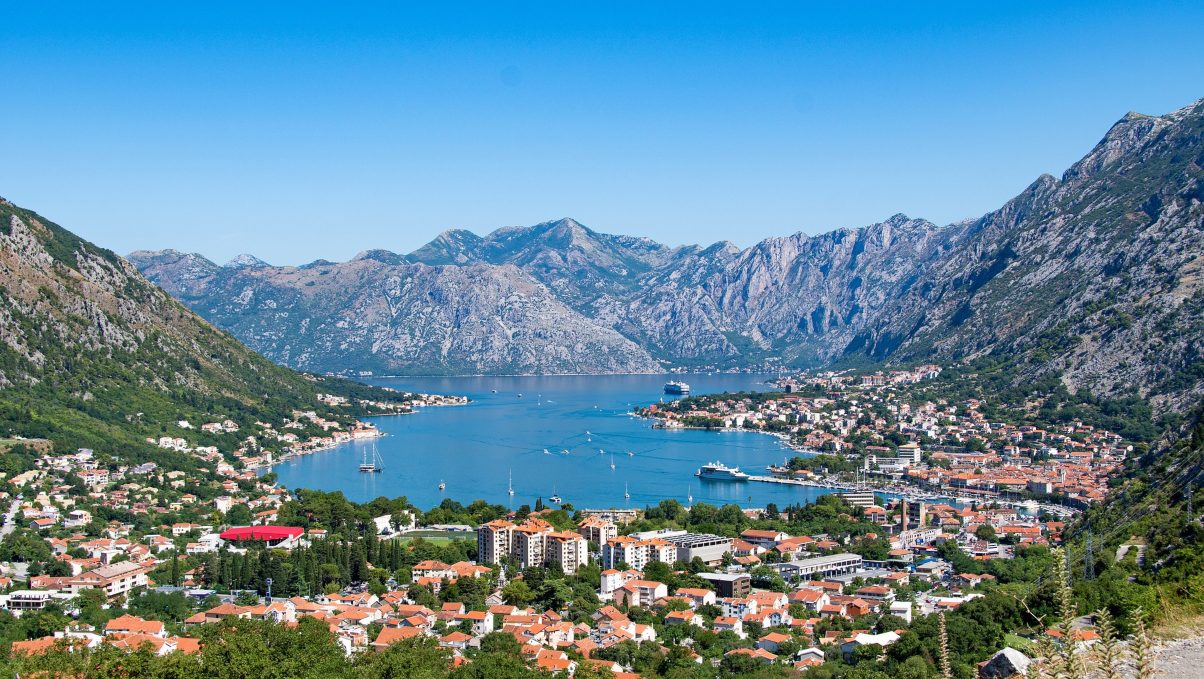 Panoramic view of Kotor Bay surrounded by lush mountains and historic coastal buildings.