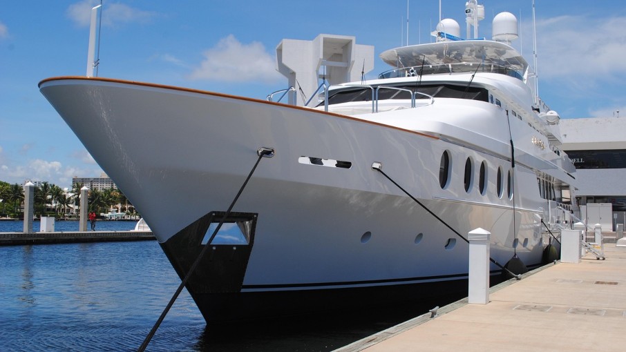 Luxury yacht moored at the pier in a modern marina - example of proper boat docking and line arrangement for safe berthing.