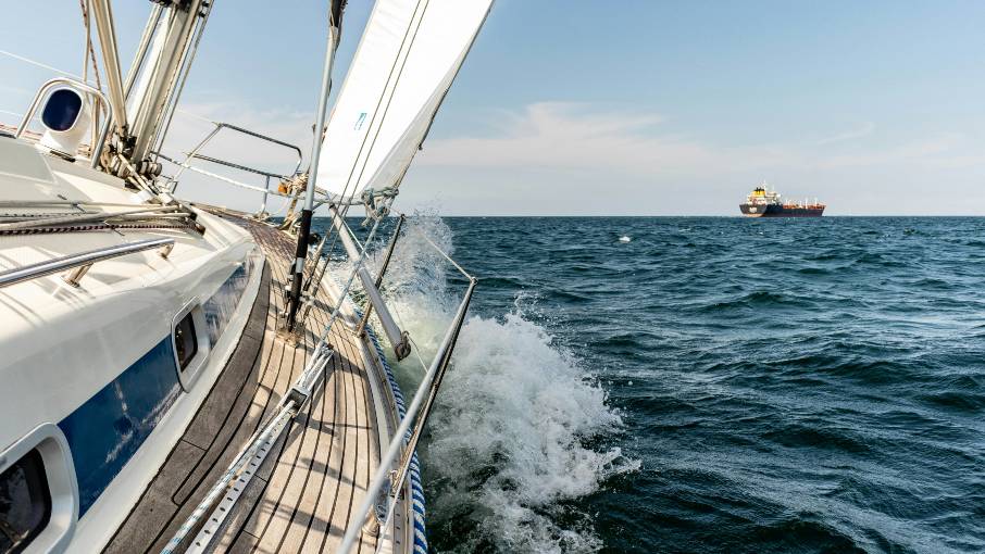 Yacht sailing across the open sea under bright summer light.