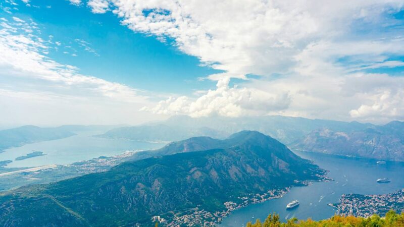 Bay of Kotor coastline with calm Adriatic water and mountains in the background.