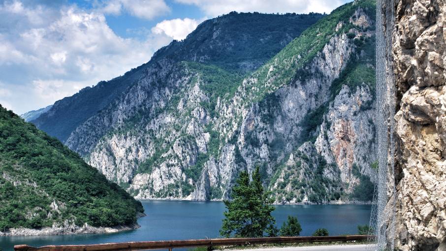 Scenic mountain road through Montenegro with lake and mountain views.